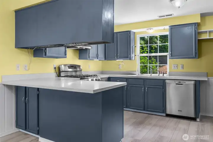 Remodeled kitchen with LVP floor, Corian counters and newer appliances that all stay.