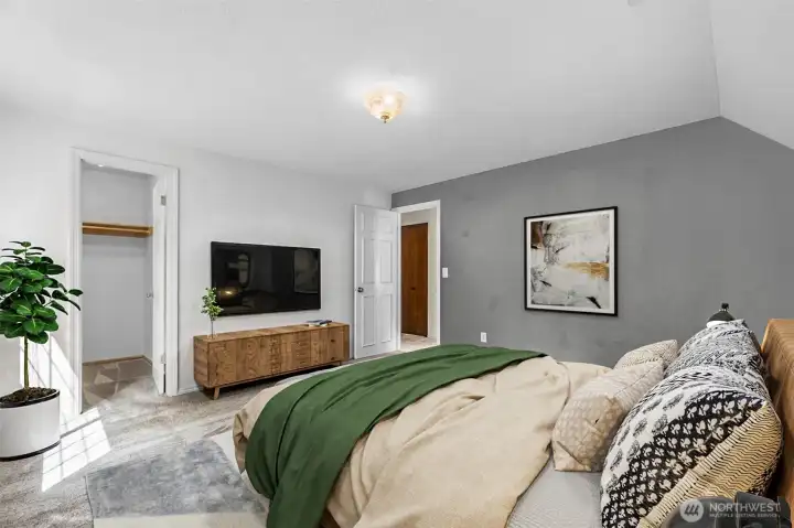 Primary bedroom with vaulted ceilings and walk in closet. This photo is virtually staged.