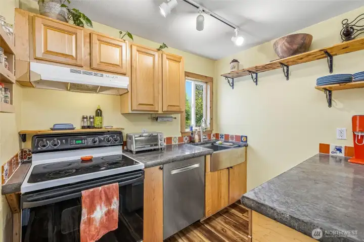 Custom concrete countertops and stainless dishwasher and sink add to the appeal. Custom concrete countertops and stainless dishwasher and sink add to the appeal.