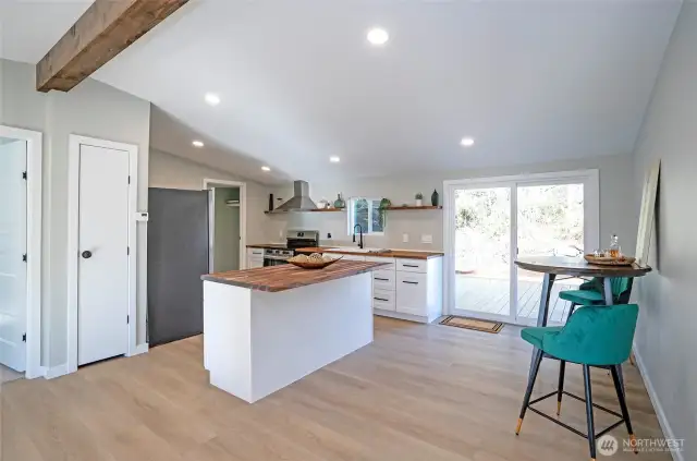 The kitchen boasts a seamless flow, complemented by a sliding glass door that opens to a brand-new backyard deck, perfect for indoor-outdoor living.