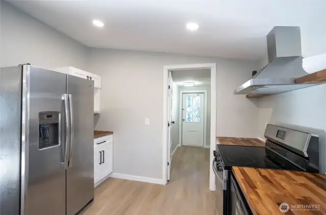 The kitchen offers additional cabinetry and expanded counter space conveniently located next to the refrigerator for enhanced storage and functionality.