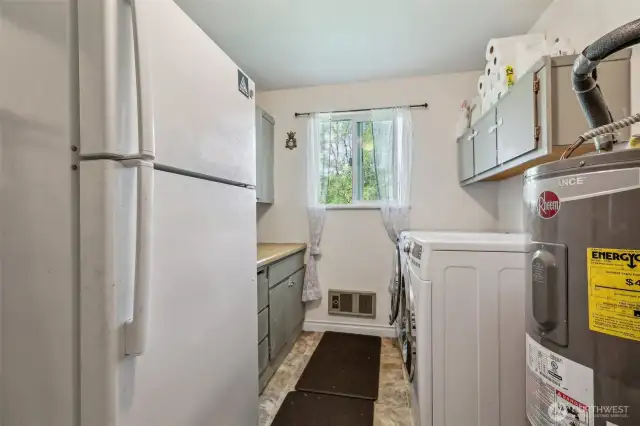 Laundry room w/washer & dryer unit, extra refrigerator & hot water heater boasting ample storage space & window