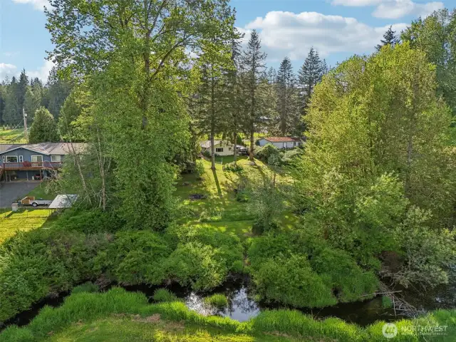 Ariel view of creek and property leading up to the house