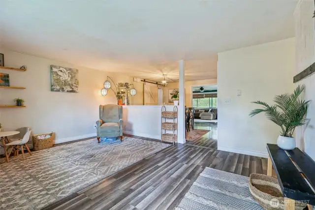 front room w/view into eating area and flowing view into living room with large window overlooking expansive backyard property