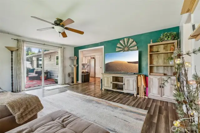 Living room w/view onto deck through sliding glass door and view into kitchen