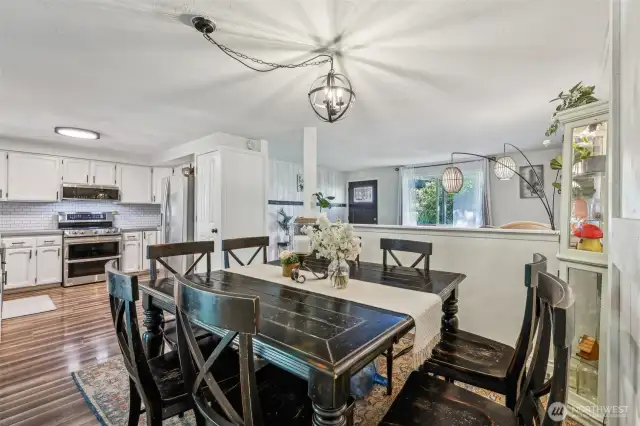 Dining area attached to kitchen w/open design, showcasing view into front room & large window to front yard.