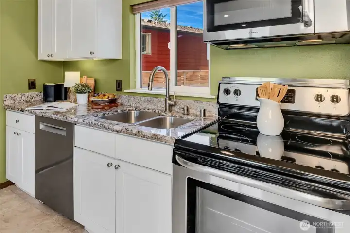 Granite and sleek stainless steel finishes dress up the open kitchen.