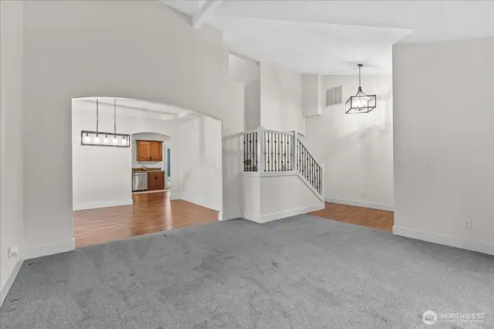 Living room looking into formal dining and kitchen. Home entry on right.