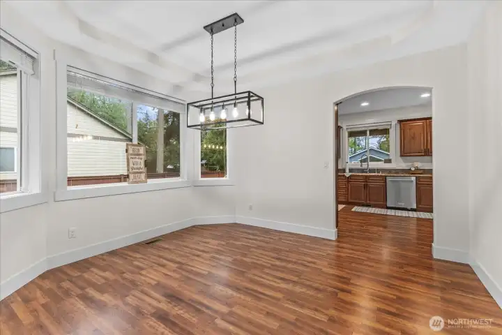 Generous-sized Formal dining room looking into kitchen. Light fixture is new. Window coverings convey