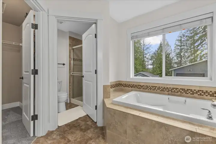 Primary ensuite bathroom includes deep, soaking tub, separate full size shower, and walk-in closet