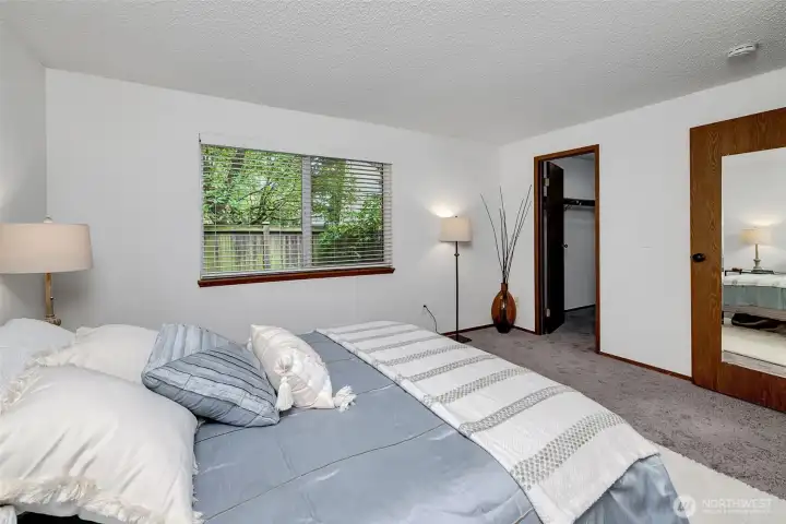 Quiet bedroom with window privacy and walk-in closet.