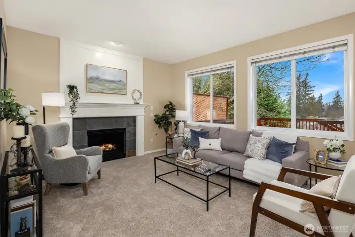 Cozy family room with gas fireplace and walls of windows that illuminate the interior with natural light.