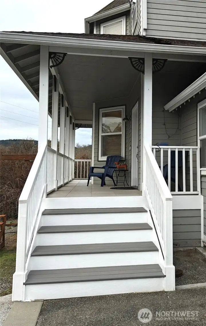 Brand new front steps leading to the front door and deck continues around the south side of the house