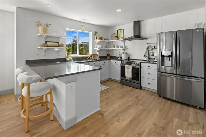 White cabinetry with open shelf uppers, stainless appliances, and quartz countertops create a smart, modern kitchen.