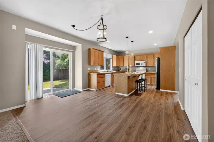 Open Kitchen area makes it Perfect for Entertaining, Lots of Space for Table & Chairs. The Sliding Glass Door leads to the Entertainment Sized Patio. Also notice the Pantry doors on the right. Notice the Beautiful New Laminate Floors!