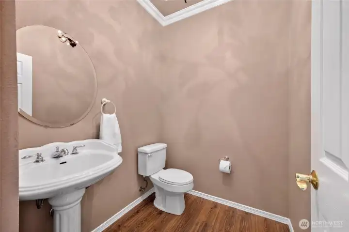 Wonderful Half Bath on Main Floor features New Laminate Floors and a Beautiful Light that casts an elegant shadow on the walss.