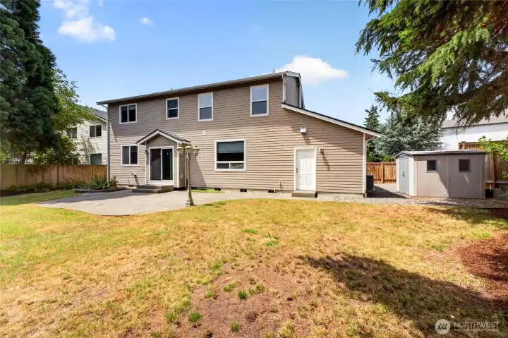Back of Home with a view of the Patio and Garden Shed on the Right.
