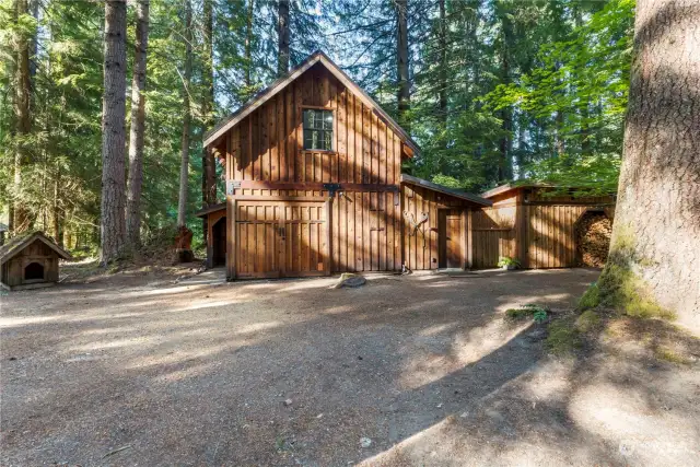 Guest cabin with upper floor sleeping/living area, 3/4 bath, kitchen with new cabinetry and appliances. Right side of the guest cabin is an attached work shop.  To the right of that, there is a detached woodshed filled to the brim with seasoned firewood.