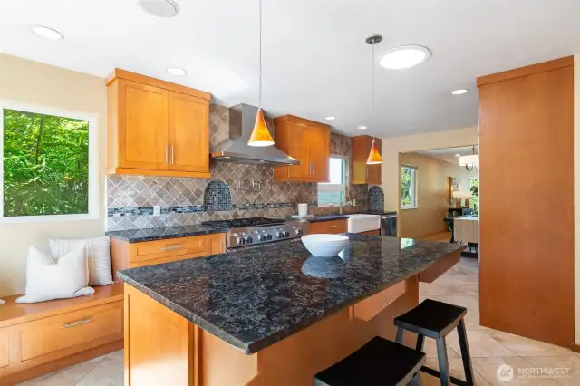 Spacious kitchen with plenty of cabinets, counter space, island with seating, window seat and more.