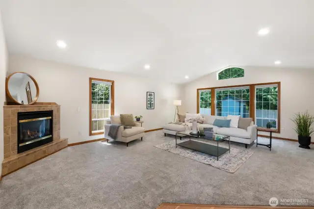 The living room features plush carpeting, a cozy gas fireplace with a tile surround.