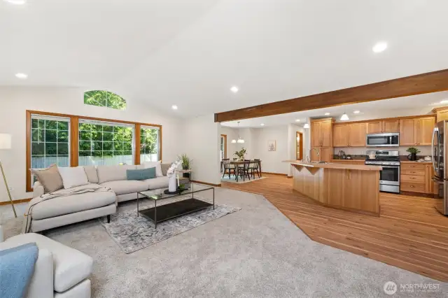 Natural light pours in through large windows, highlighting the vaulted ceilings and warm wood accents.