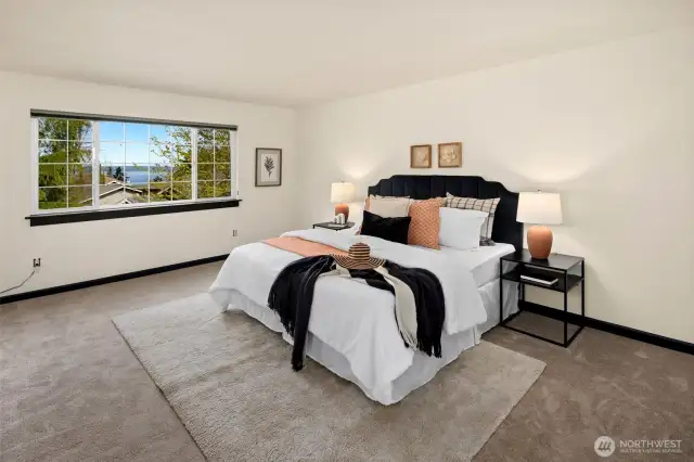 Take in a serene view of Puget Sound from bed—this airy primary suite offers restful vibes and room to breathe.