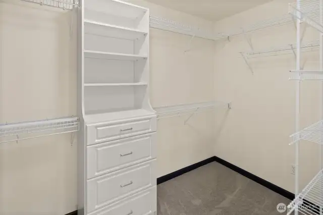 The walk-in closet in the primary suite provides excellent built-in drawers, shelving, and generous hanging space.