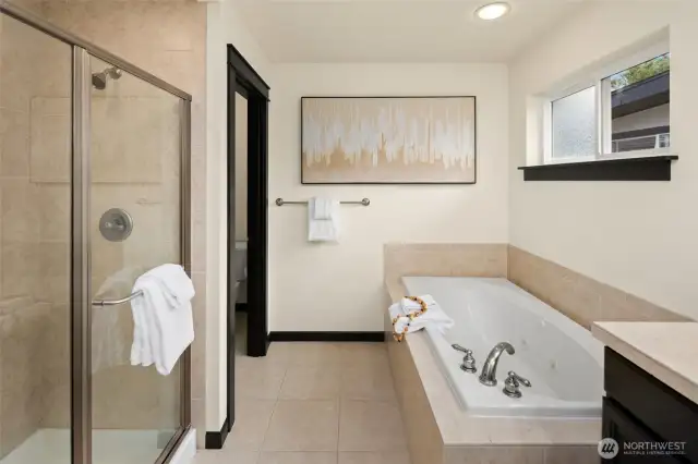 A separate glass-enclosed shower and oversized soaking tub bring spa-like comfort to the beautifully appointed ensuite.