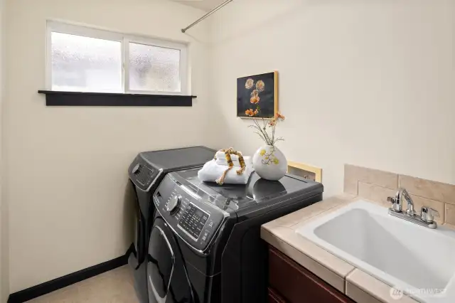 A dedicated, upstairs laundry room with a large utility sink and cabinet storage adds function and ease to your daily routine. Handsome, side-by-side, full-size graphite washer and dryer!