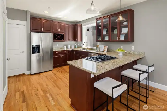 A classic U-shaped kitchen with generous granite counter space, stainless appliances, and rich cabinetry—ideal for both weeknight meals and weekend prep.