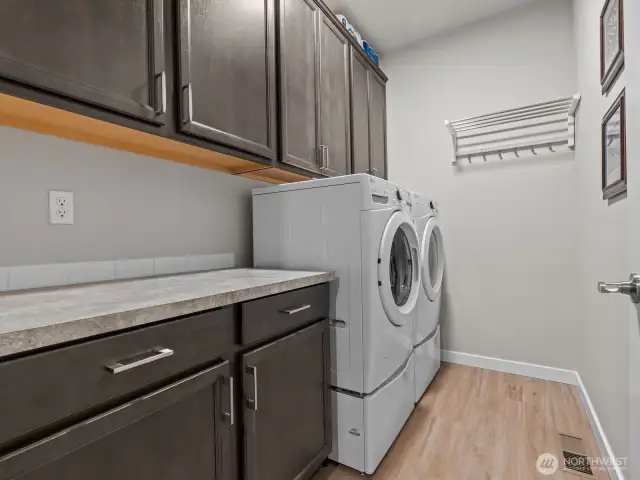 Adjacent, you'll find the strategically placed laundry room with plenty of additional storage. One of the many upgrades throughout the home.