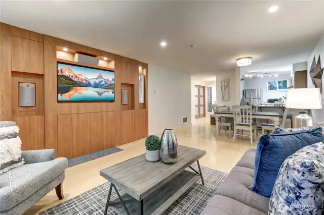 Wall of beautiful built-ins with wood-burning fireplace hiding behind doors