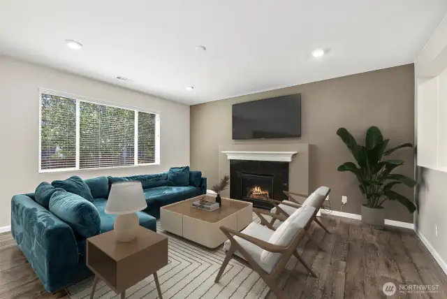 **Partially virtually staged** Cozy space for living room with natural light beaming in. Features gas fireplace and wall-mount for your TV.