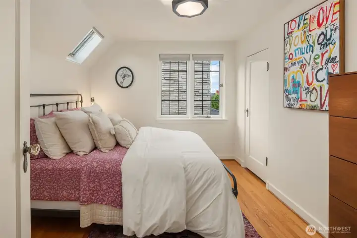 One of three bedrooms on upper level with skylights