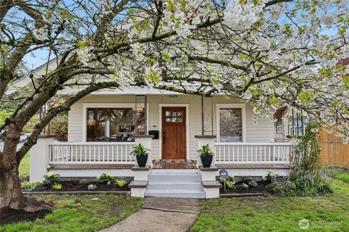 Fresh landscaping with vibrant flowers creates a warm welcome. Fully fenced yard offers privacy and space for outdoor living, pets, or gardening.
