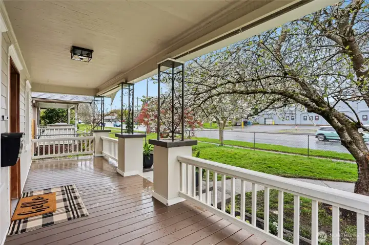 Expansive covered porch with newly crafted deck and railing—warm, welcoming, and made for slow mornings and easy evenings. Framed by blooming trees and greenery, it’s the kind of space buyers fall for the moment they arrive.