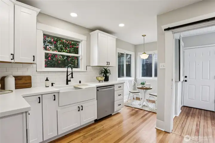 Beautifully updated kitchen with crisp white cabinetry, quartz counters, and stainless appliances—clean, bright, and effortlessly functional. Farmhouse sink and subway tile add timeless appeal, while the cozy breakfast nook invites slow mornings and casual dining. A space that truly feels like the heart of the home.