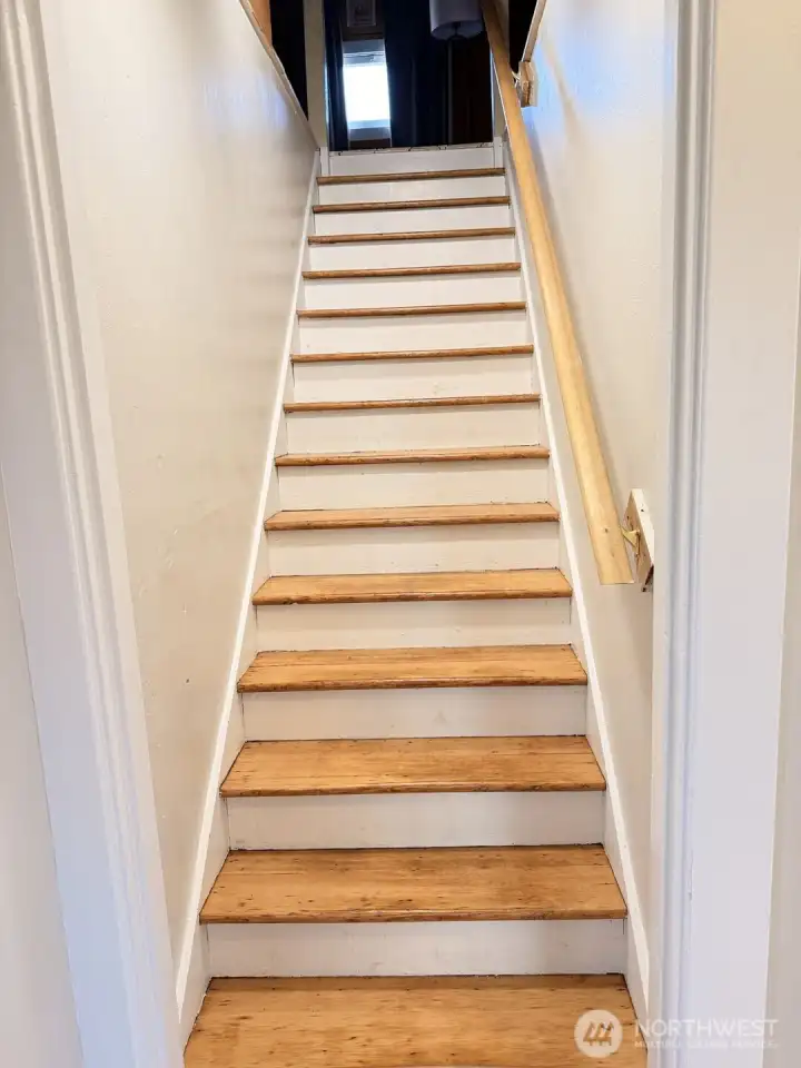 Charming staircase leads to a cozy upper-level retreat—full of character with warm wood detailing and versatile space perfect for a bedroom, office, or creative nook. A tucked-away hideaway that feels both inviting and full of possibility.
