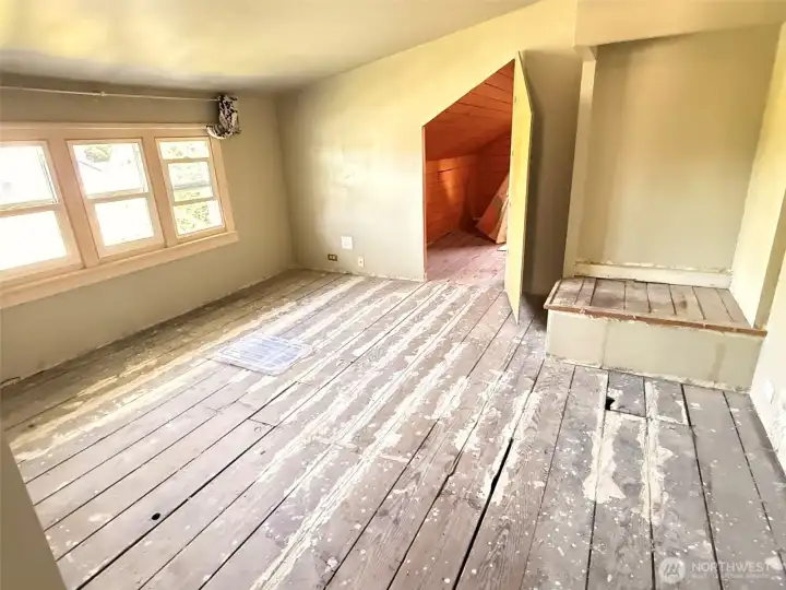 Versatile upper-level space full of potential—ideal for a home office, art studio, or creative retreat. Showcased here virtually staged, this area highlights the charm of the original wood floors and natural light, offering endless possibilities to make it your own.