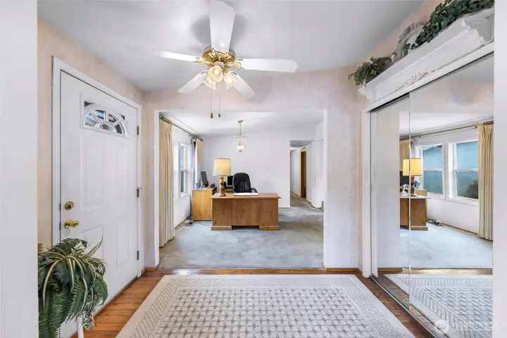 Front foyer with mirrored coat closet, ceiling fan, and adjacent flex room ideal for office or family room use