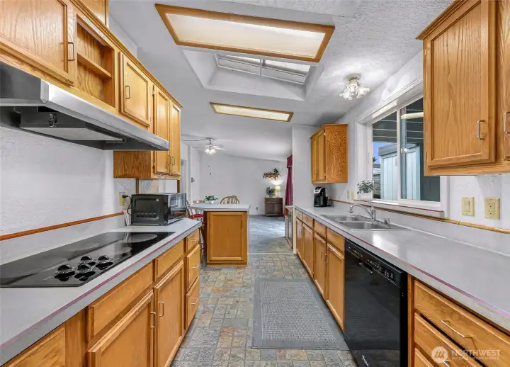 Galley-style kitchen with extensive counter space, abundant cabinetry and seamless flow to the dining space