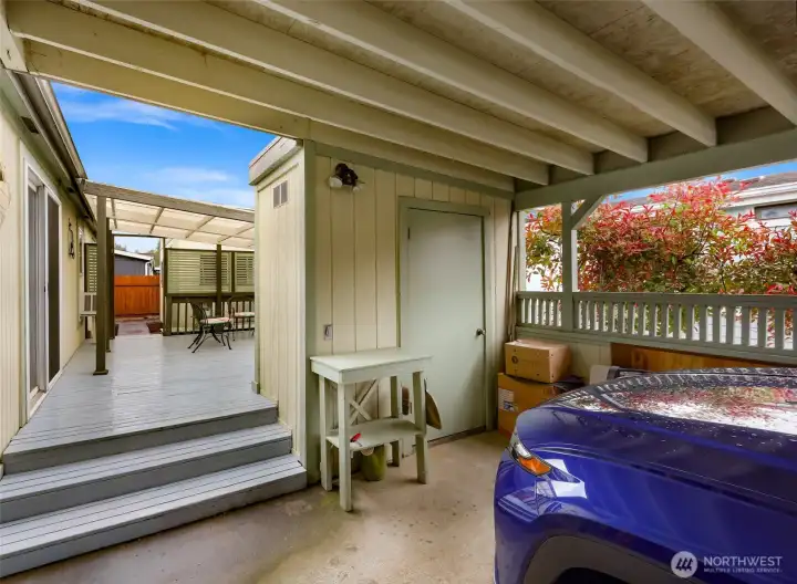 Protected carport area with attached storage and easy access to the covered deck and kitchen, offering practical everyday convenience in all seasons
