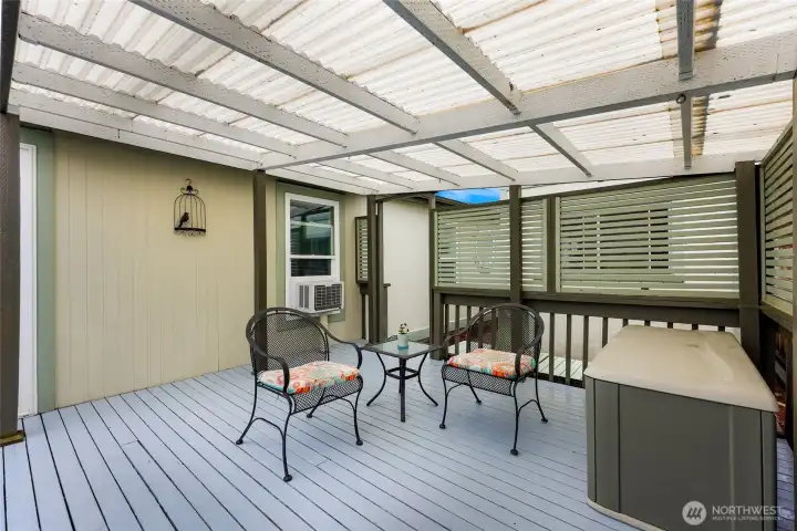 Private covered deck featuring weather protection, screened privacy accents, and inviting space for outdoor dining or quiet relaxation throughout the seasons