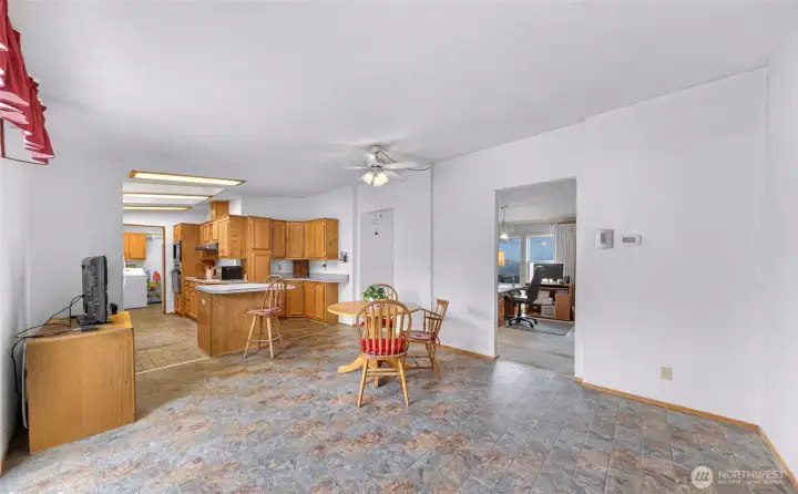 Bright dining space with open-concept flow to the kitchen, breakfast bar seating, and direct access to the covered deck for effortless entertaining