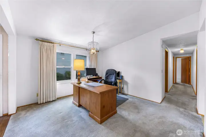 Flexible living space with large window and ideal setup for office, den, or family room use