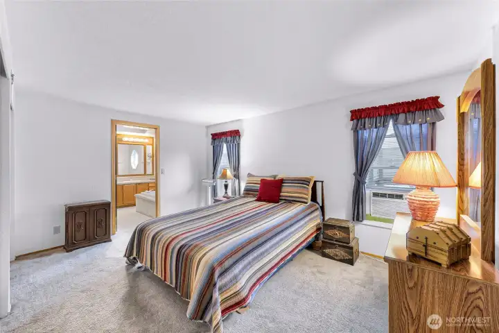 Primary suite with soft natural light, spacious layout, and direct access to the private ensuite bath for added convenience