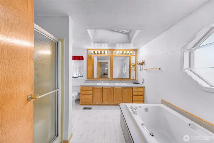Ensuite bath offering dual sinks, relaxing soaking tub, separate shower, and abundant cabinetry