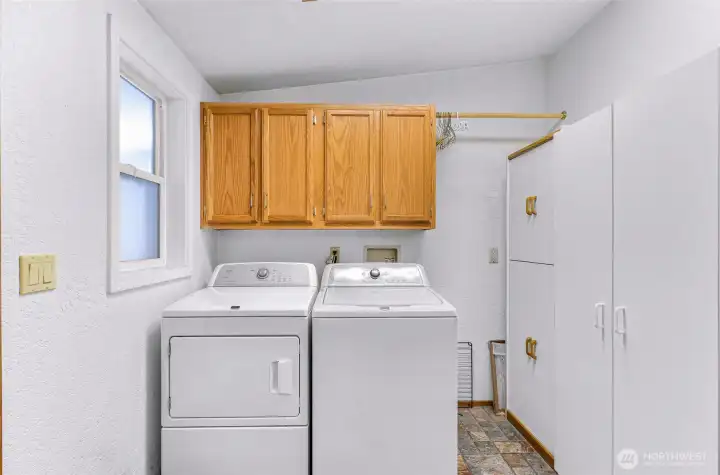 Laundry/utility room with upper cabinets, additional storage space, and hanging area