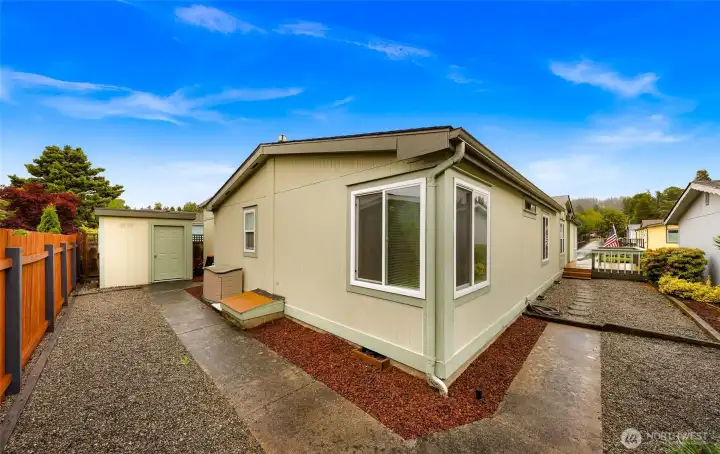 Easy-care gravel walkways, and a detached storage/workshop building for added flexibility. Corner windows bring natural light indoors