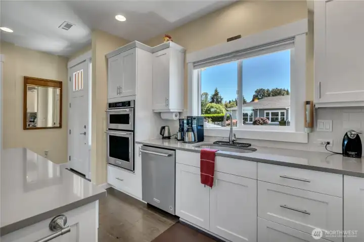 Beautiful white shaker cabinetry and generous quartz counter tops accented with neutral tones + wonderful natural lighting